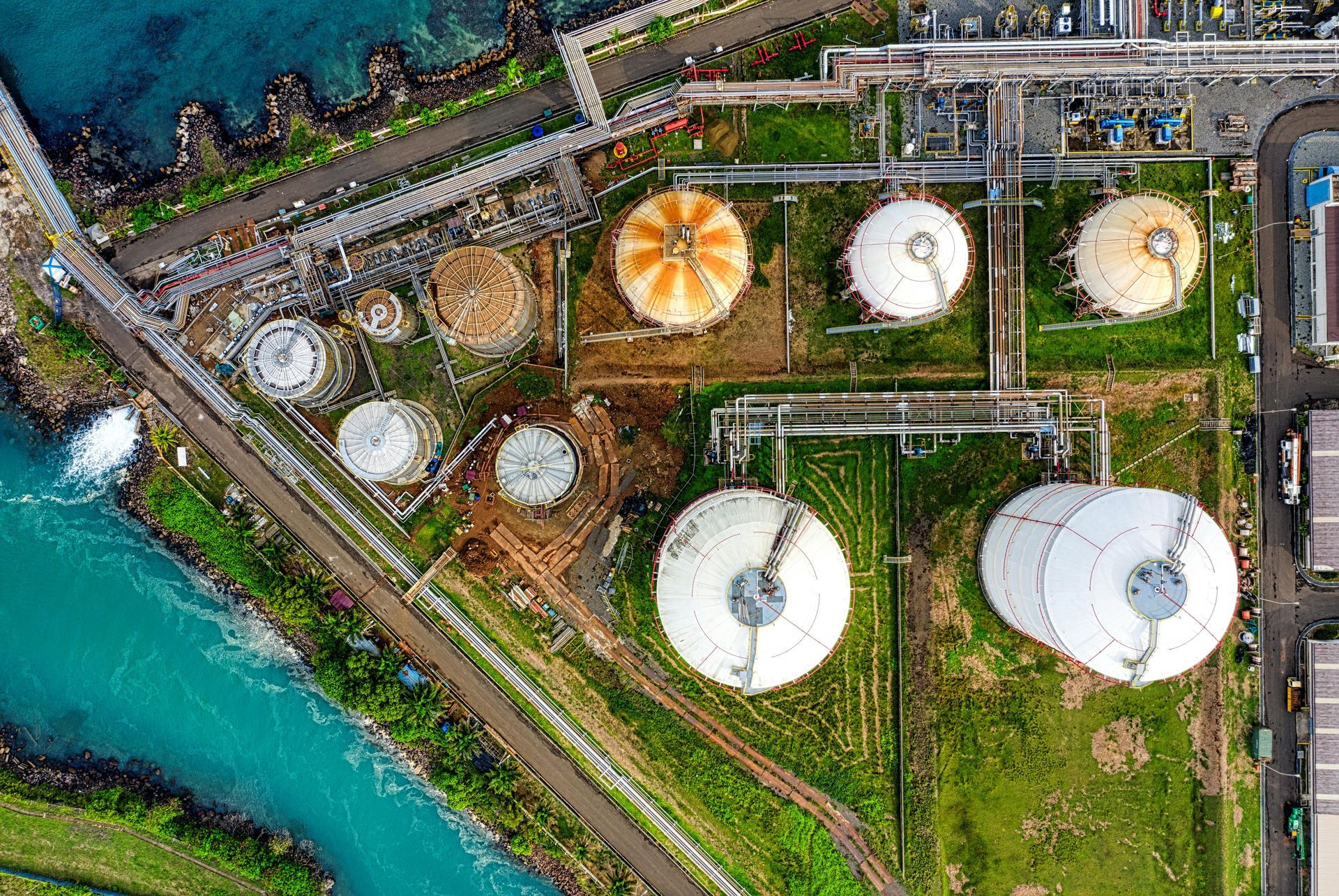 An aerial view of a large oil refinery next to a river.