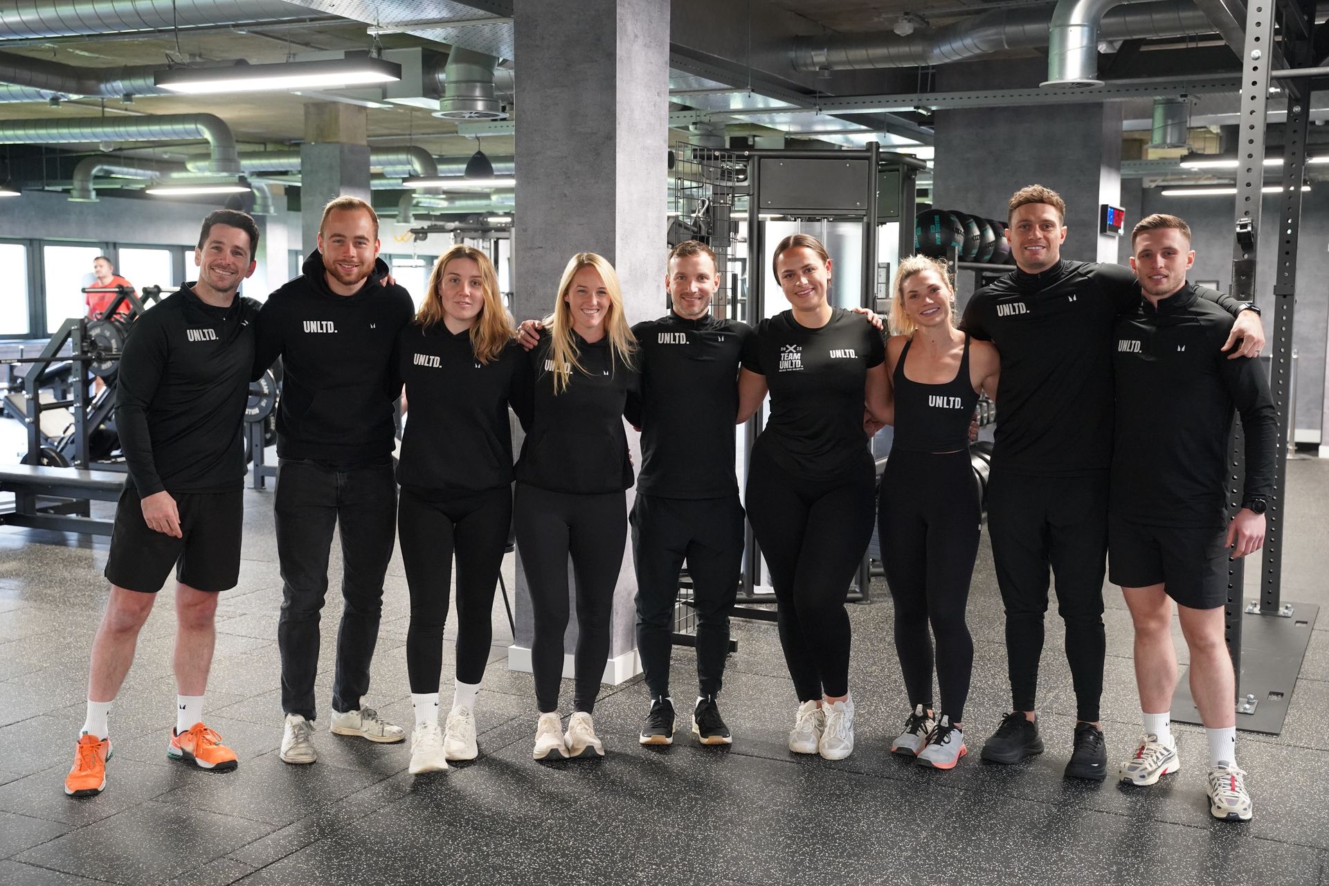 A man and a woman are holding ropes in a gym.