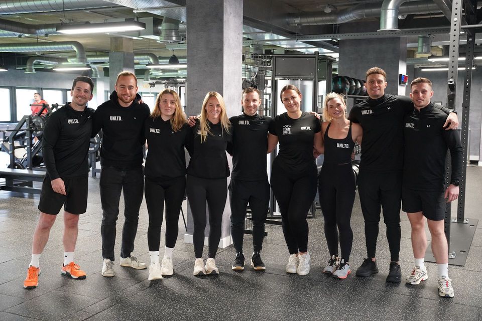A man and a woman are holding ropes in a gym.