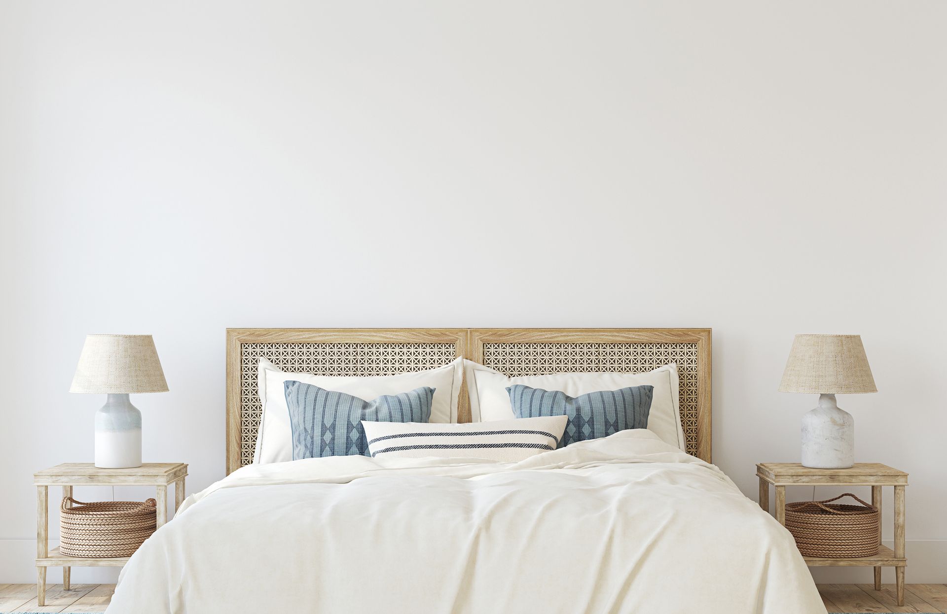 A bedroom with a bed , nightstands , lamps and a wicker headboard.
