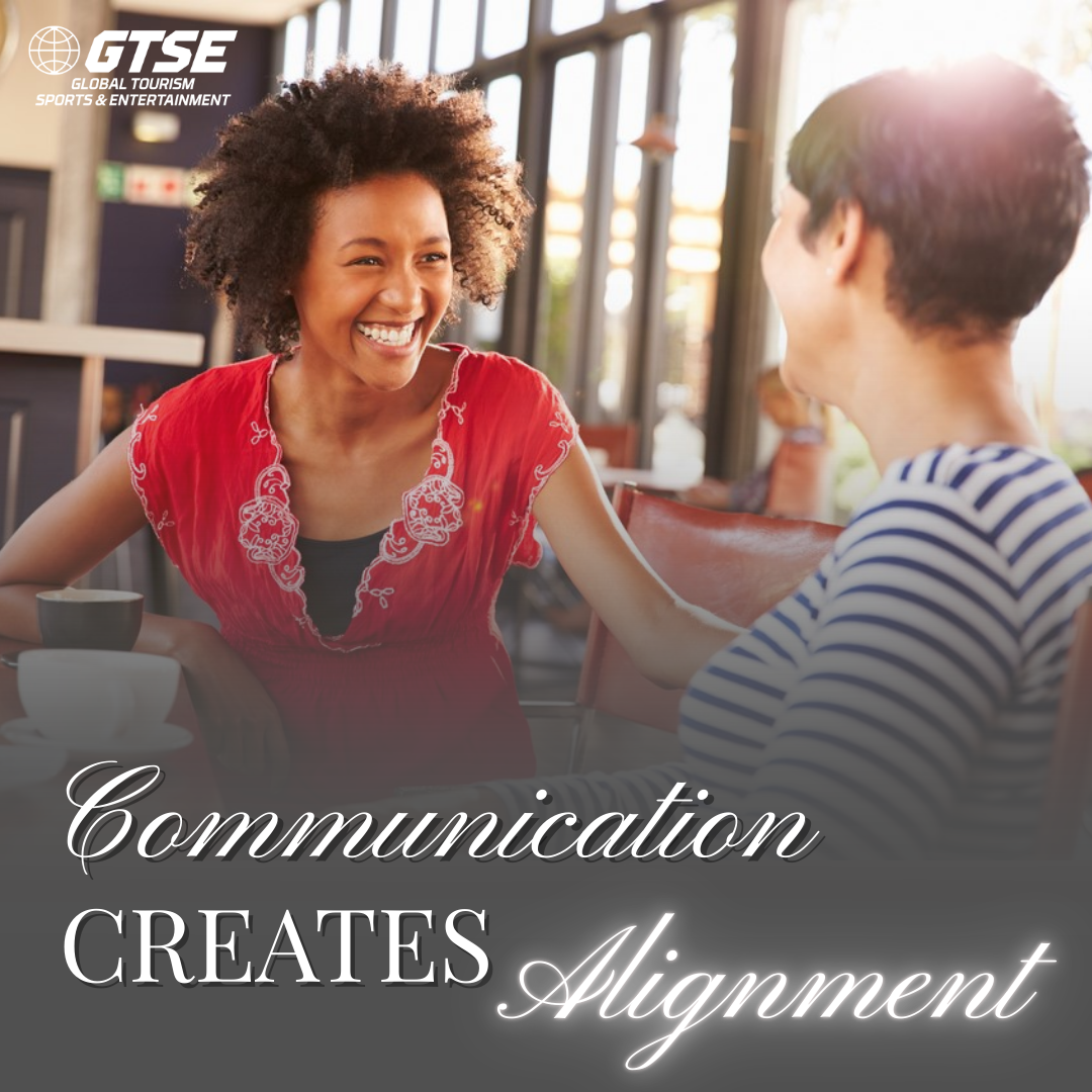 Two people sit at a cafe table laughing together. Overlay text reads: 