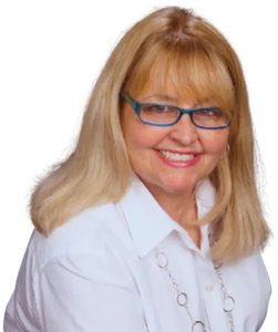 Wendy White smiling with blonde hair and blue glasses wearing a white blouse on a white background