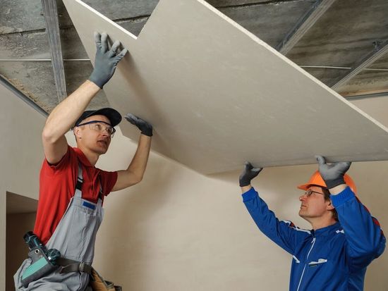 Two of our employees lifting drywall