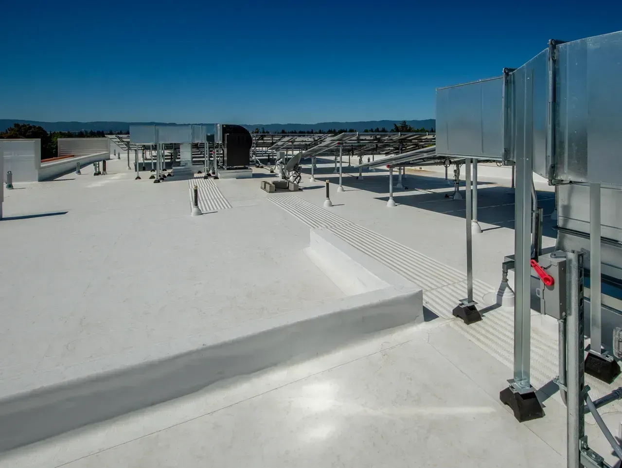 A white roof with a lot of pipes on it