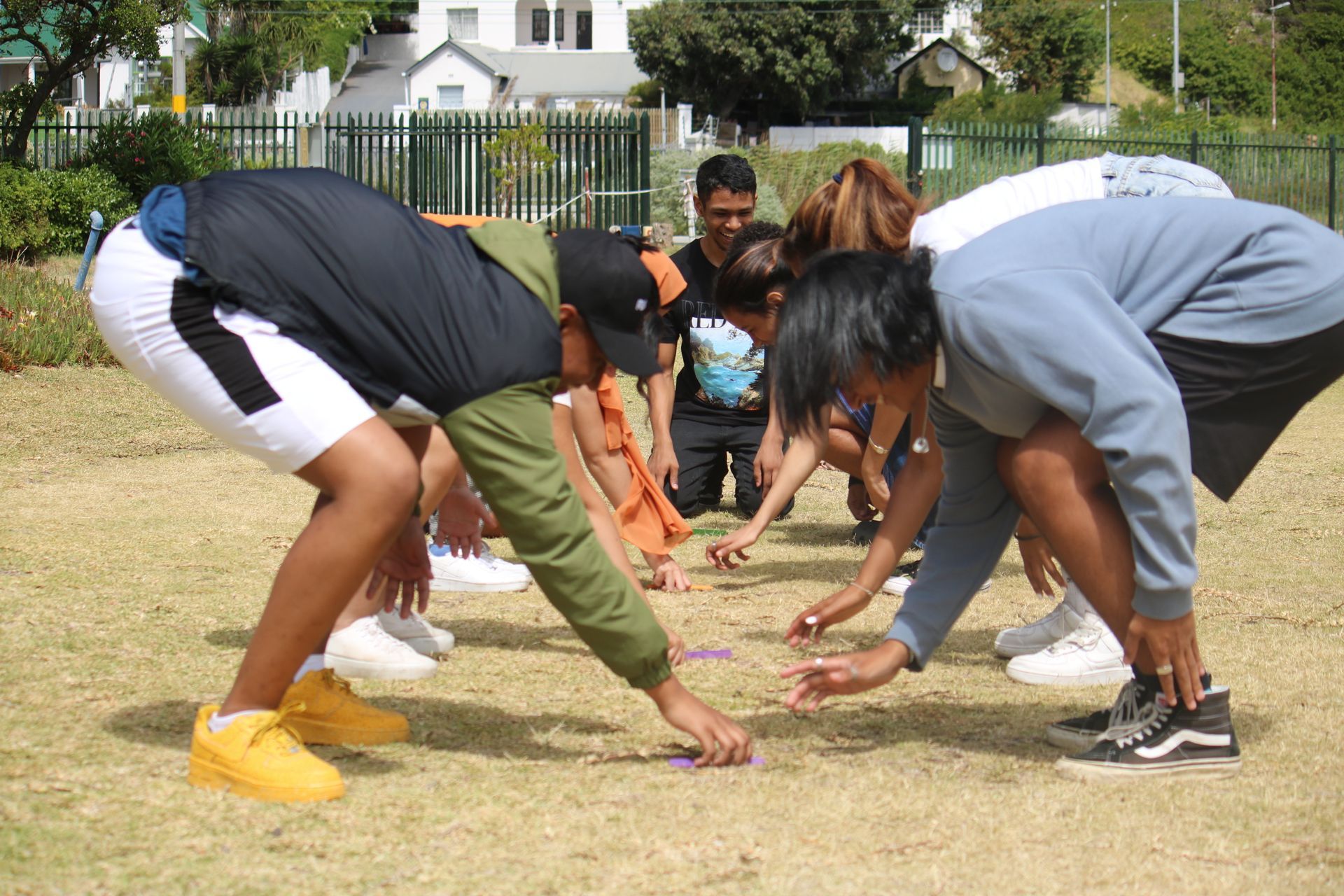 a group of people are squatting on the grass in a field .