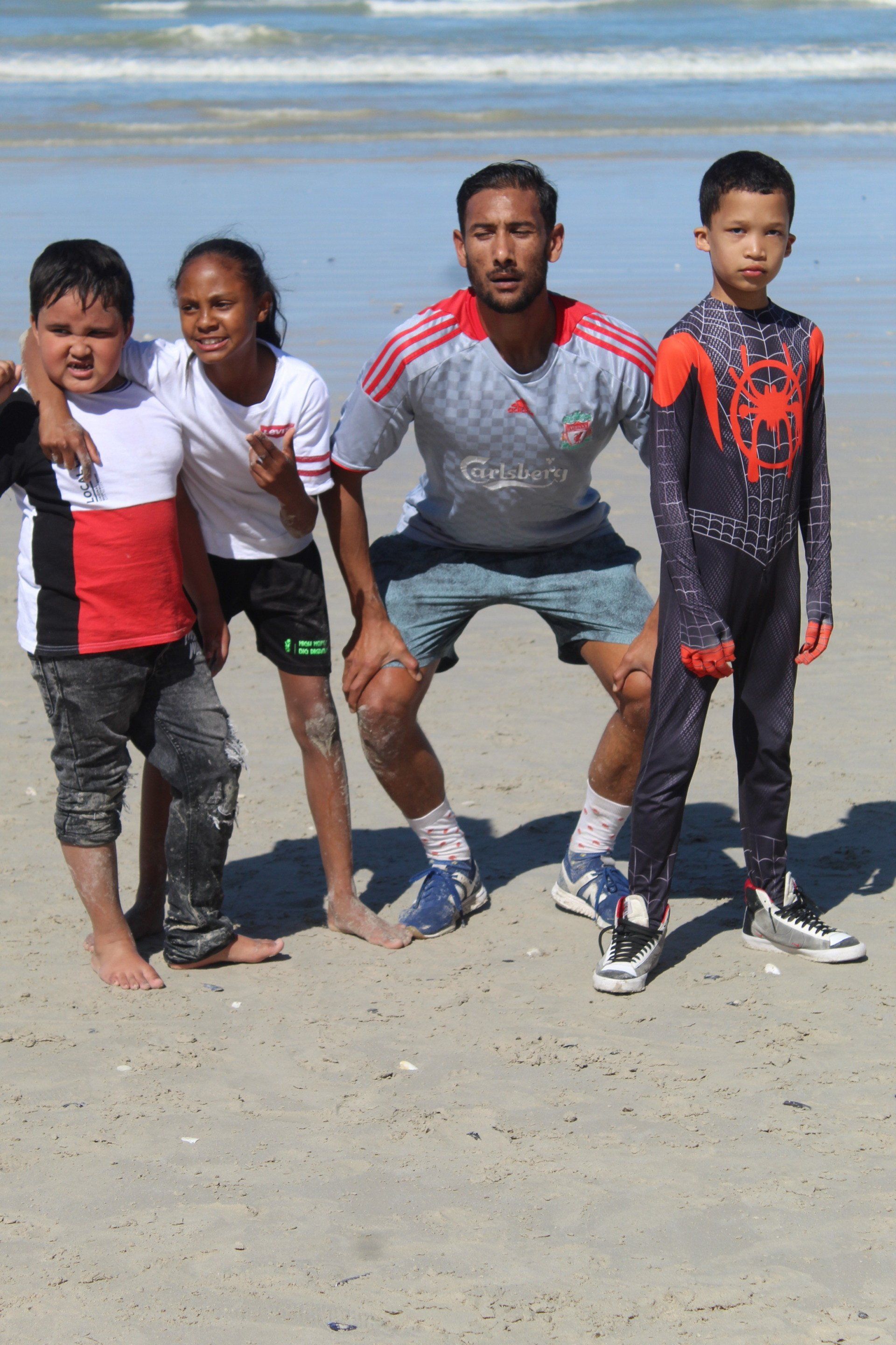 a group of children posing for a picture on the beach