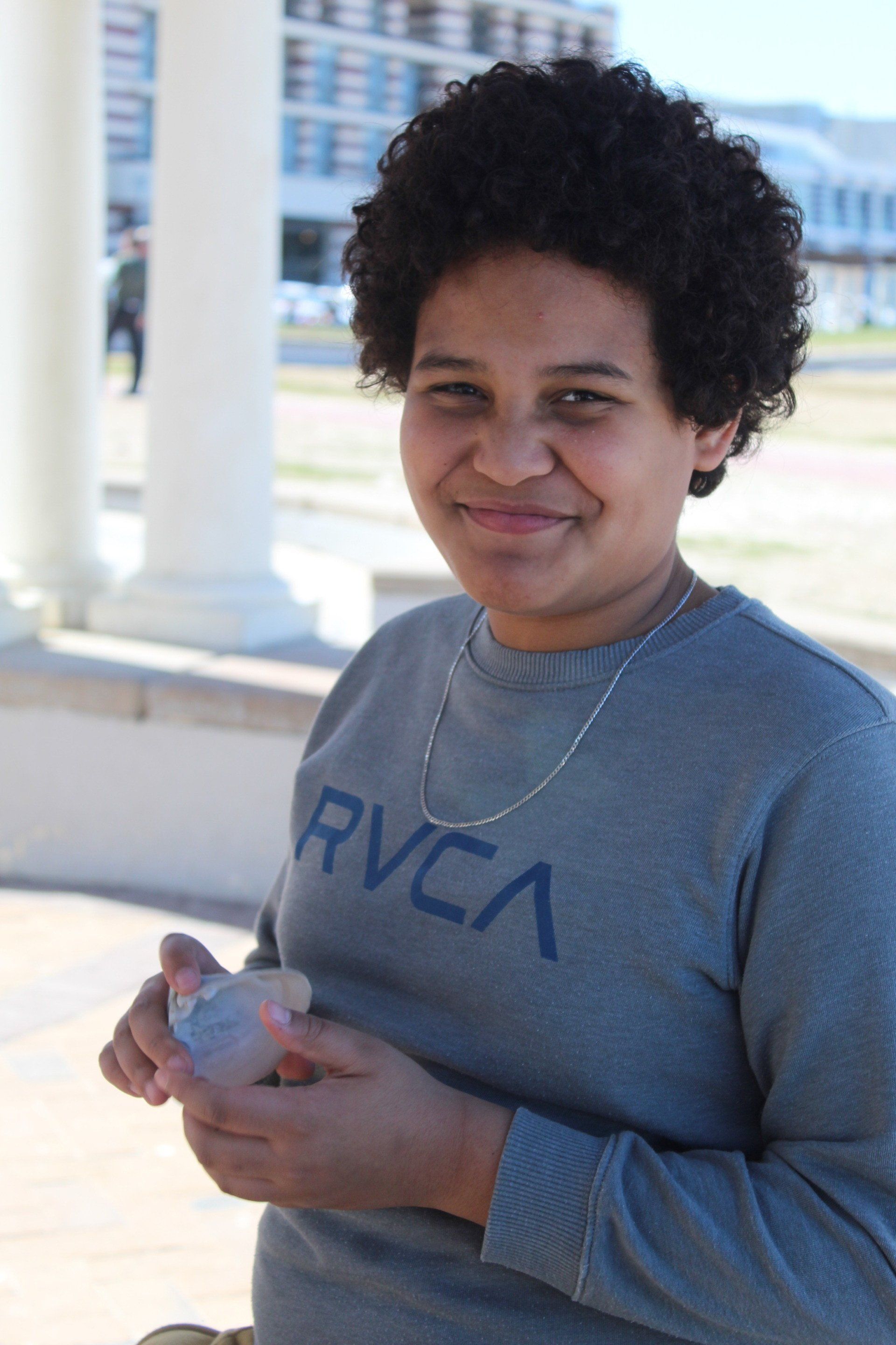 a woman wearing a grey sweater with the word rvca on it