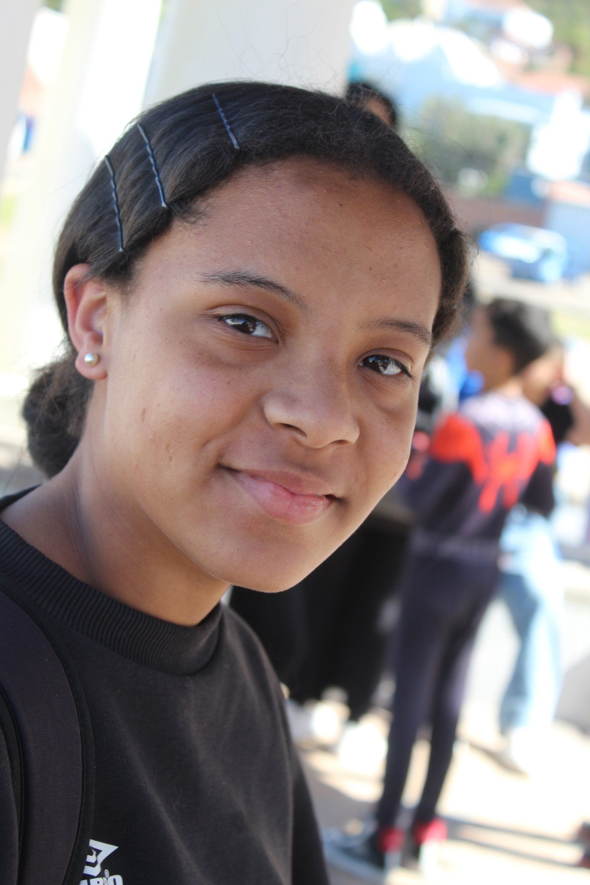 a young girl wearing a black shirt is smiling for the camera .