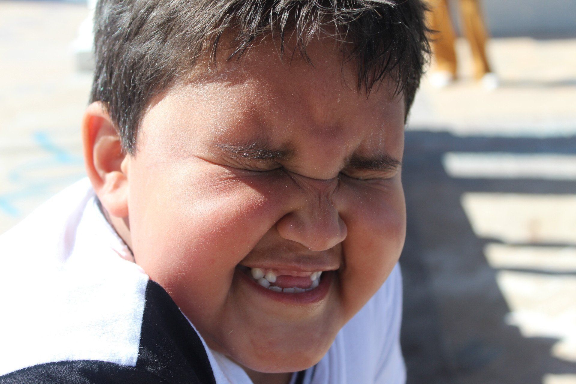 a young boy making a funny face with his eyes closed