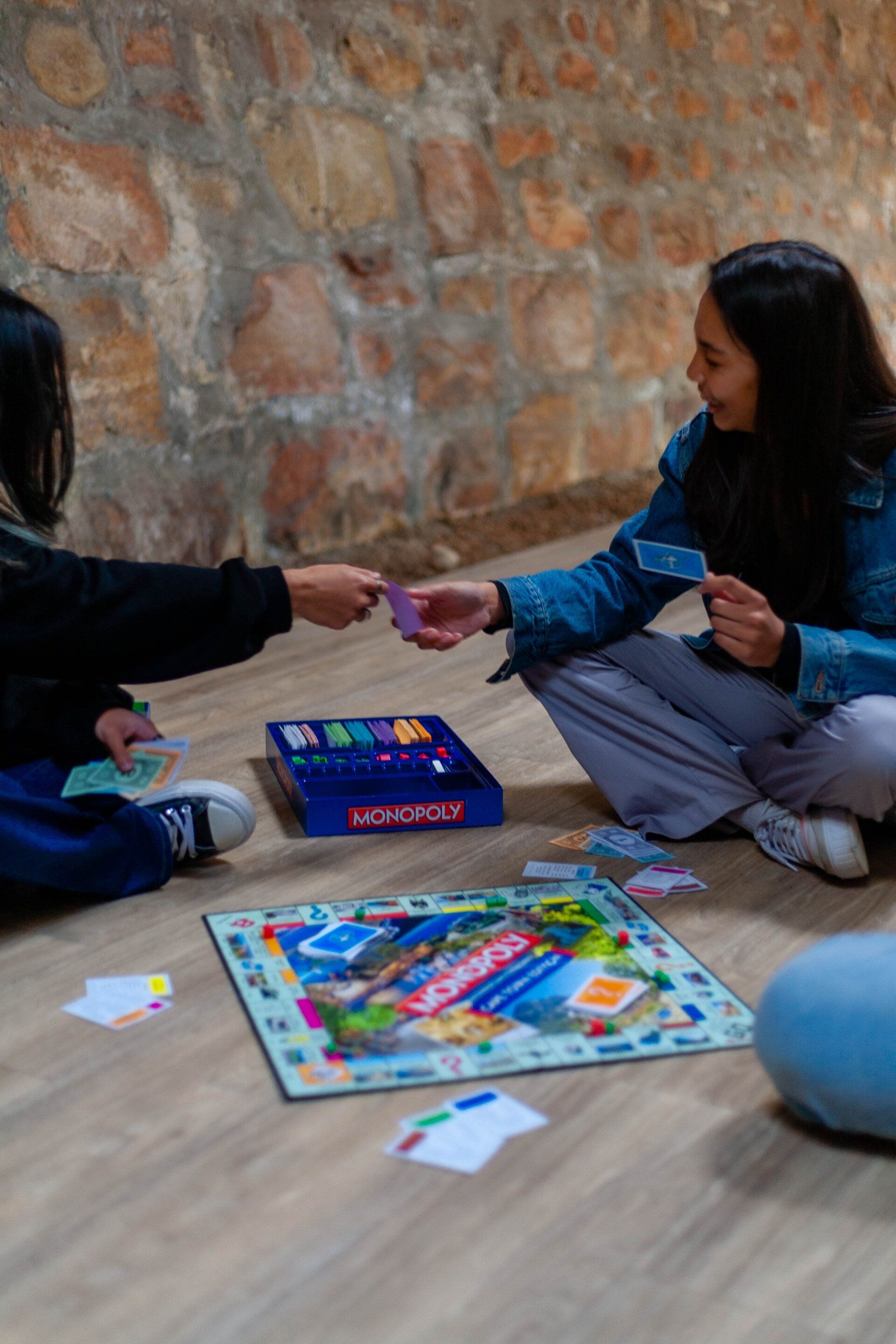 a group of people are sitting on the floor playing a board game .
