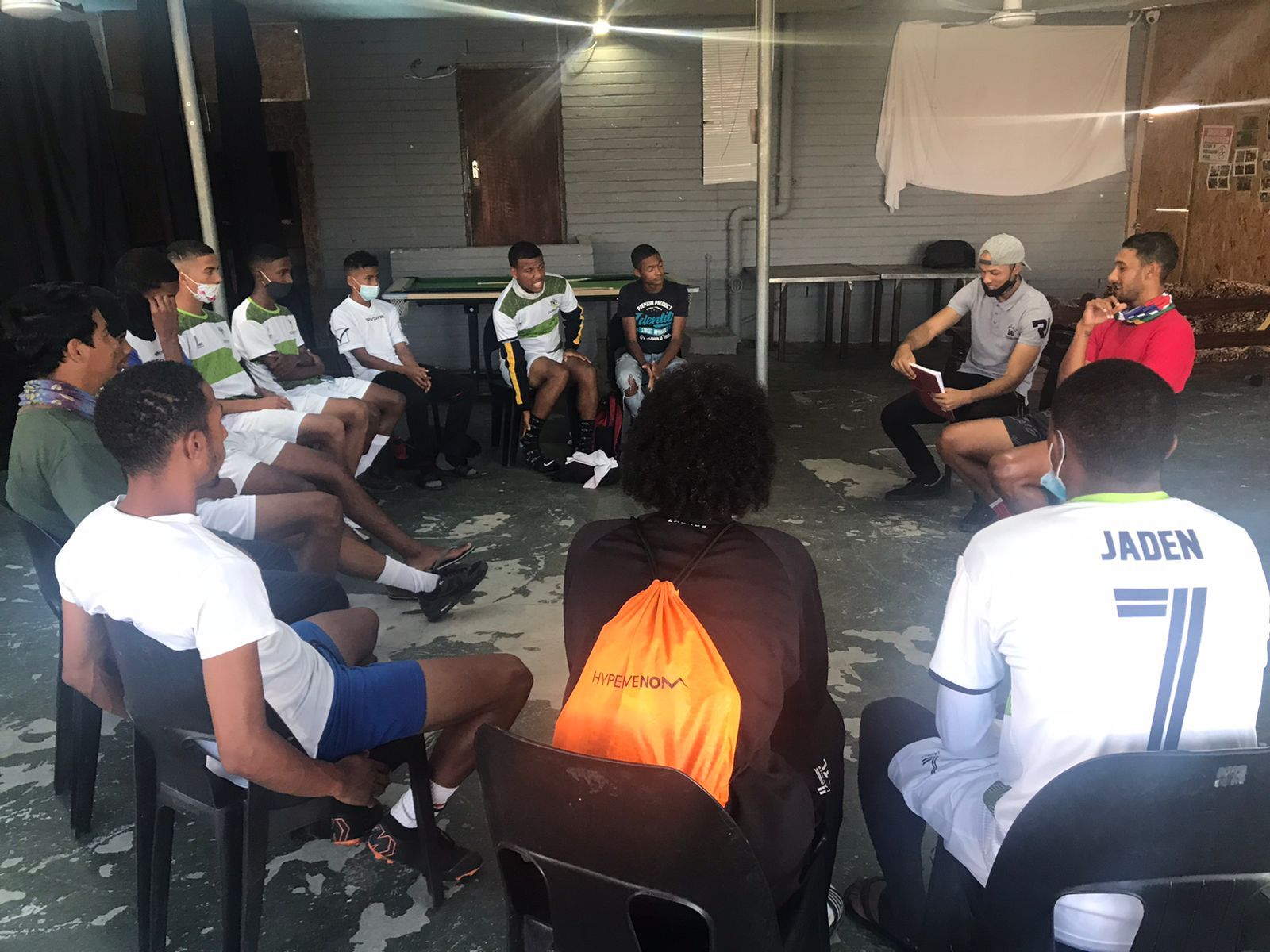 a group of young men are sitting in a circle .