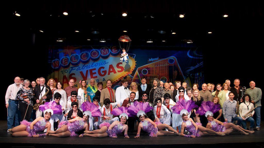 Group of performers posing on a stage in front of a