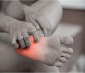 Person touching sole of foot, highlighted in red, indicating pain or injury.