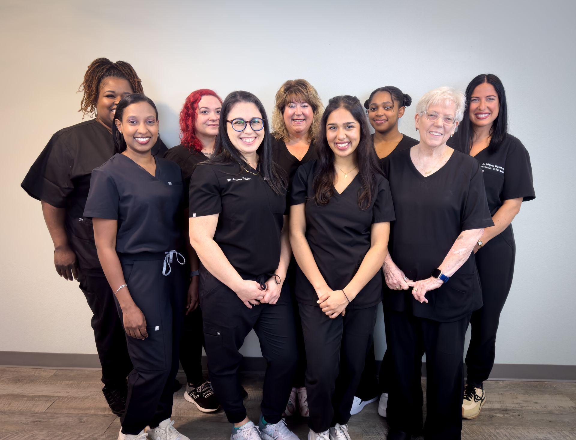 A group of women are putting their hands together in a circle.