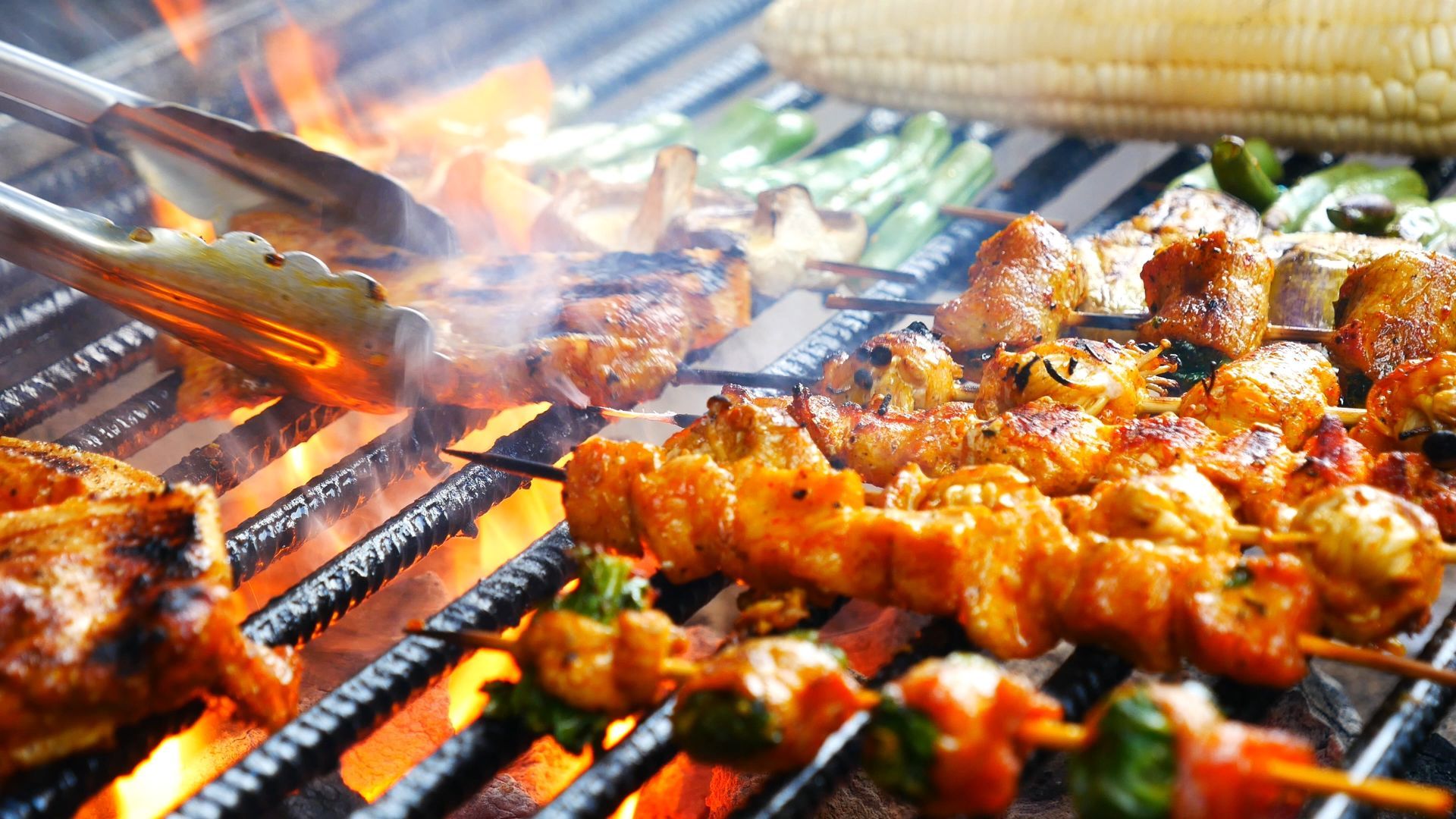 A bunch of food is cooking on a grill.