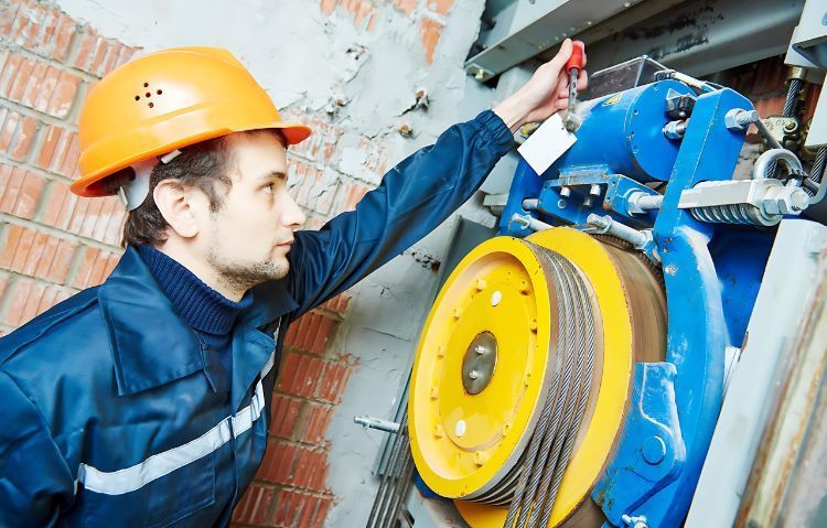 technician working on elevator sheave re-grooving