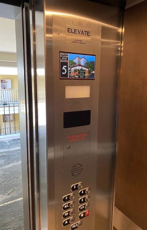 Close-up image of elevator buttons with numbered floor selections and alarm functions.