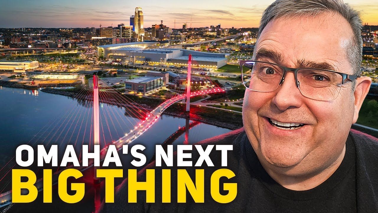 Man in glasses smiling, superimposed on Omaha skyline with red bridge and text