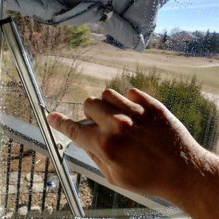 A person is cleaning a window with a cloth