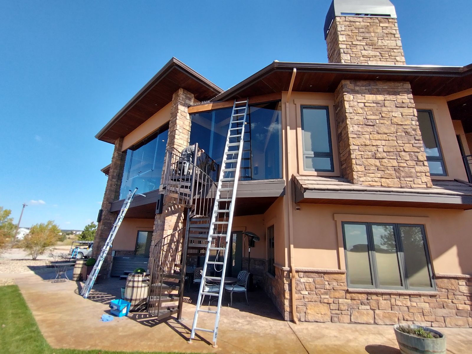 Book online at https://www.transparentcleaningcompany.com/residential-window-cleaning Residential Window cleaning project in Colorado Springs by Transparent Cleaning Company- featuring ladders and a glass-enclosed deck.