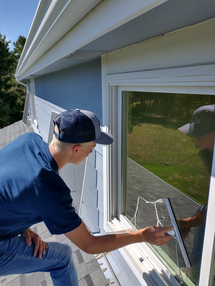 Worker Cleaning Roof Window | Colorado Springs, CO | Transparent Cleaning Co.