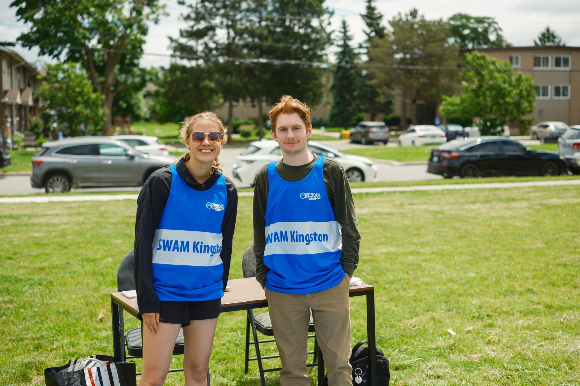 A man and a woman are standing next to each other in a field.