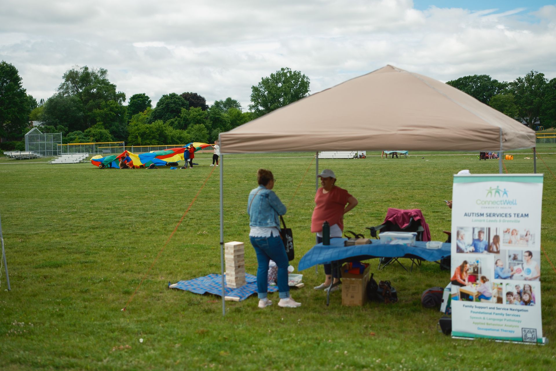 A group of people standing under a tent in a field