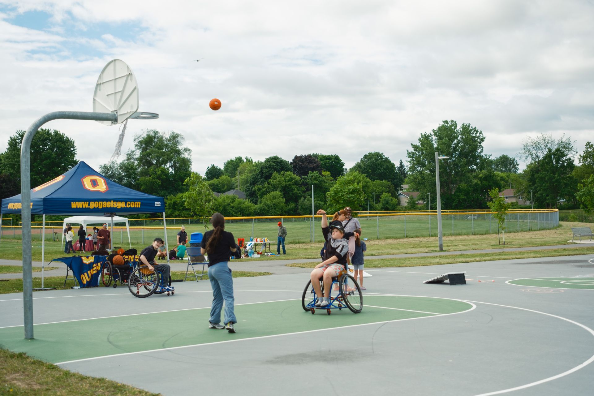 A group of people in wheelchairs are playing basketball on a court.