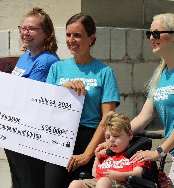 A group of people holding a check that says kingston on it