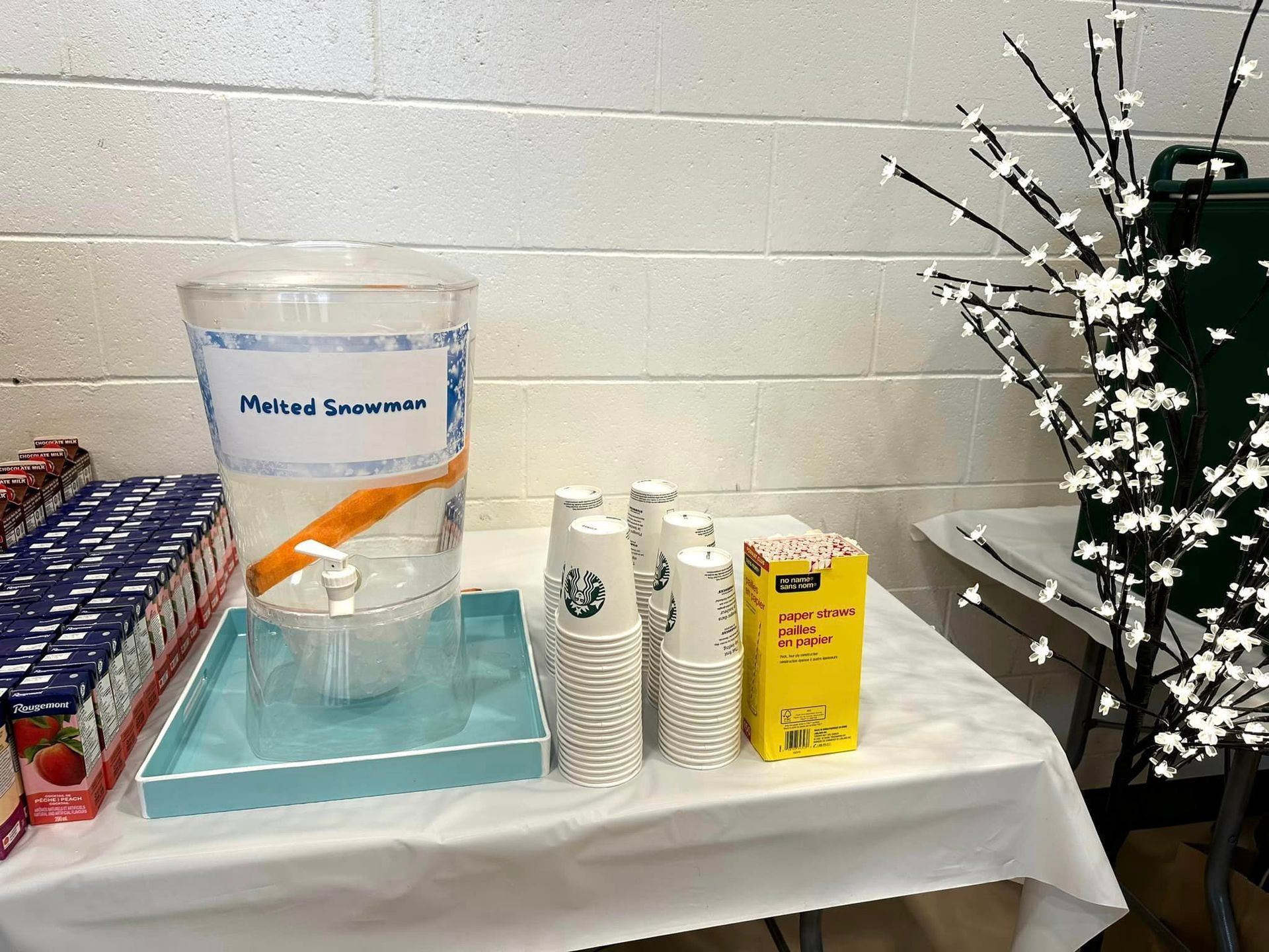 A table with a pitcher and cups on it