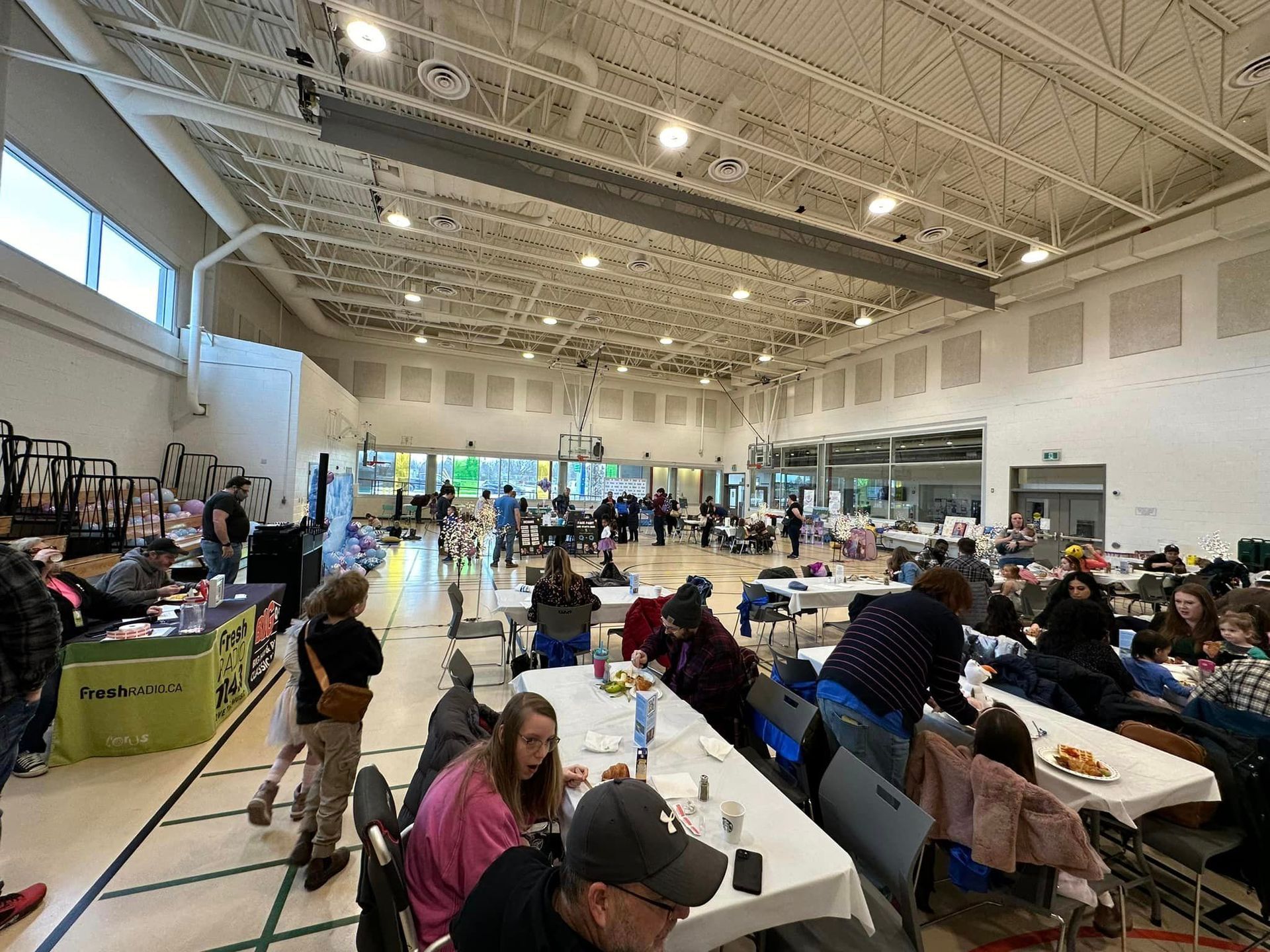 A group of people are sitting at tables in a large room.