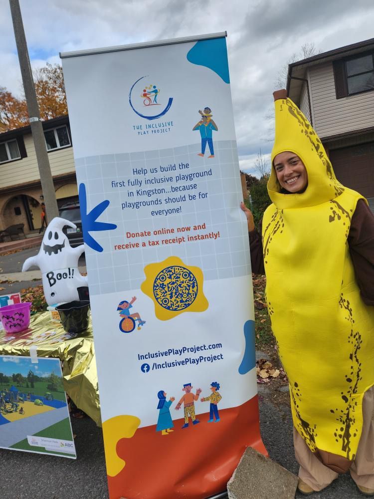 A woman in a banana costume is standing in front of a sign.
