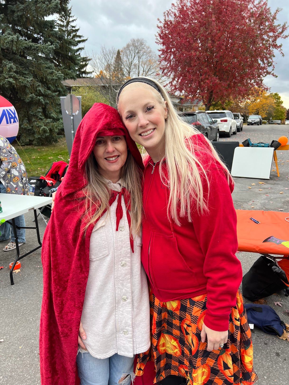 Two women dressed as little red riding hood and little red riding hood are posing for a picture.