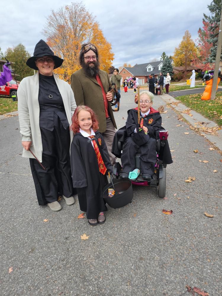 A group of people dressed in halloween costumes are standing on a street.