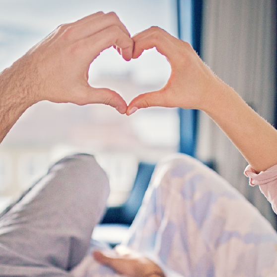 Um homem e uma mulher estão sentados no topo de uma montanha olhando para as montanhas.