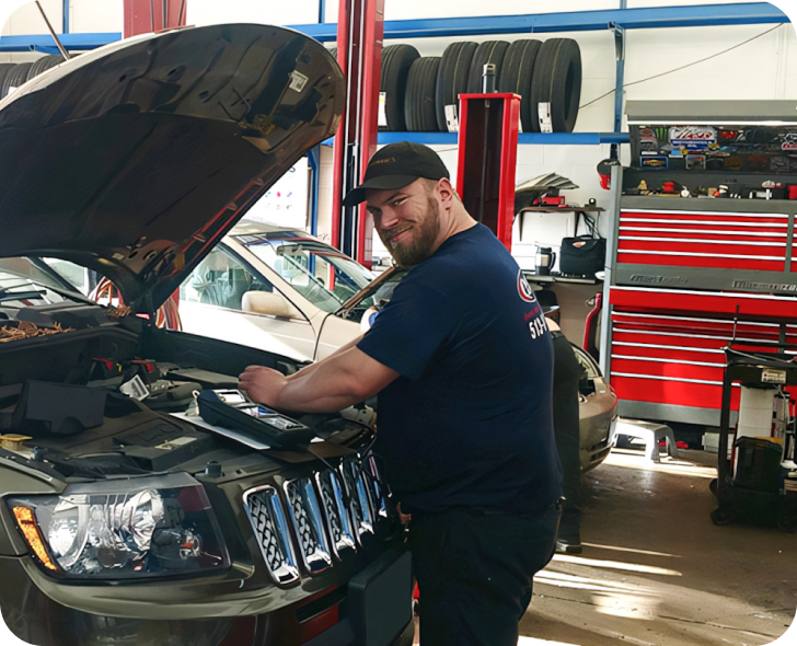 A man is working under the hood of a jeep | Parkway Automotive