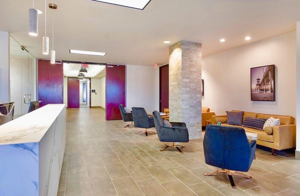 A lobby with a couch , chairs , and a counter.