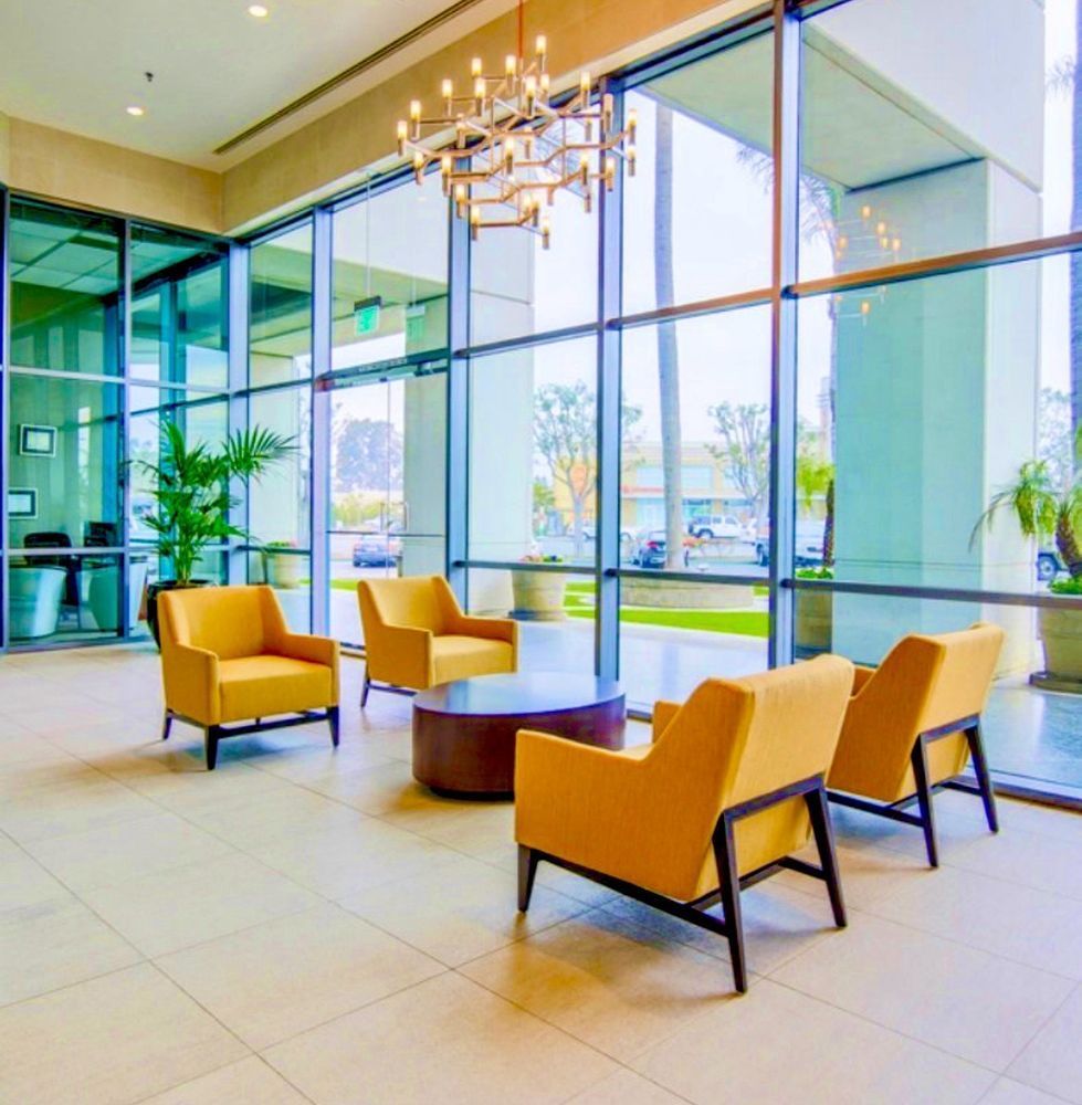 A lobby with yellow chairs and a coffee table