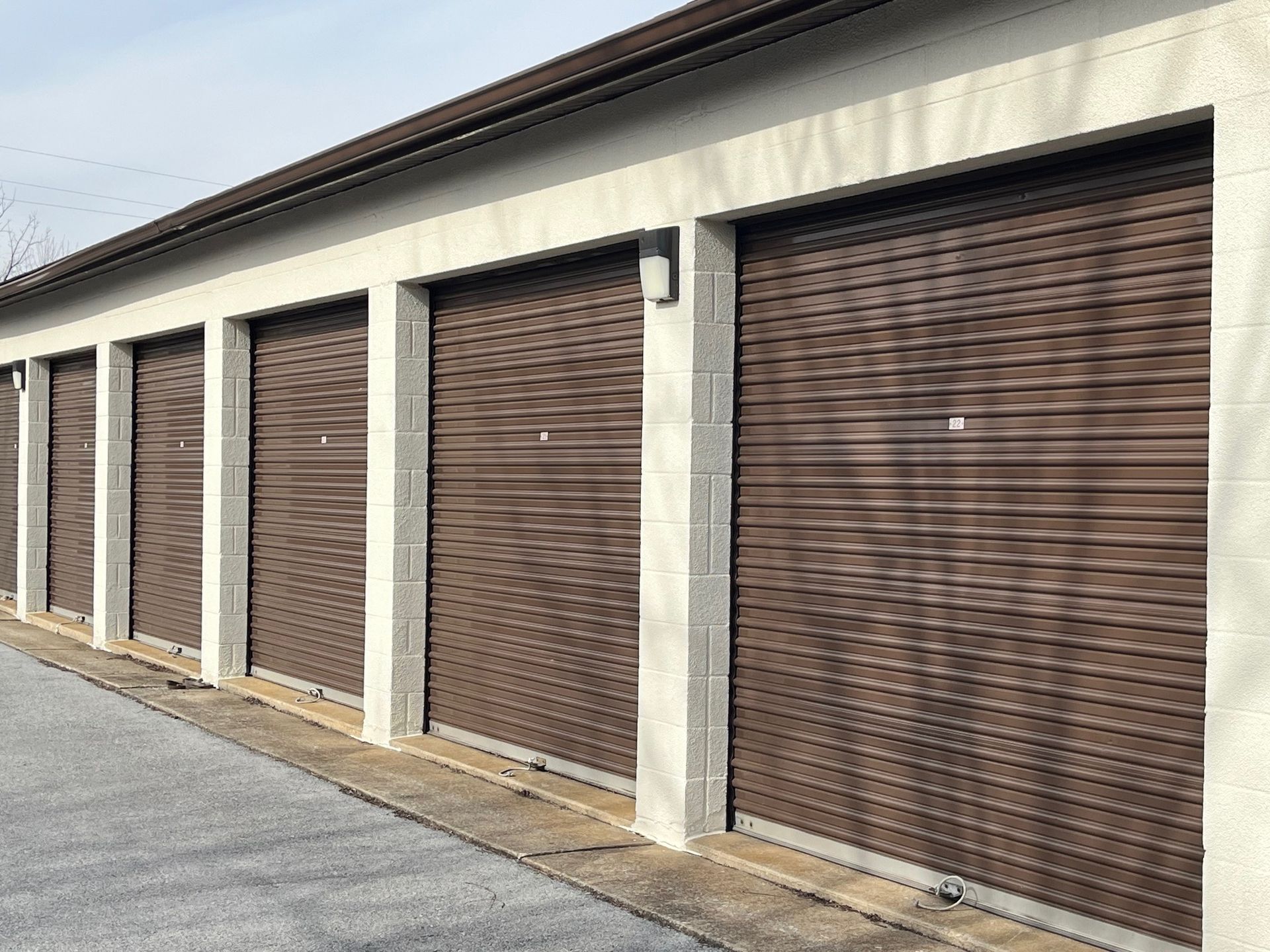 A row of brown garage doors on a building.