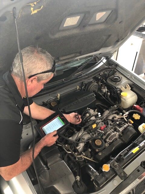A Man Is Working on The Engine of A Car — GT Auto Center in Tweed Heads South, NSW