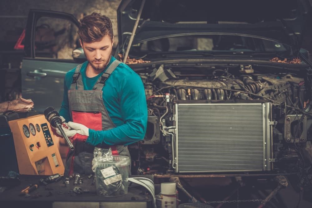 A Man Is Working on A Car Engine in A Garage — GT Auto Center in Tweed Heads South, NSW
