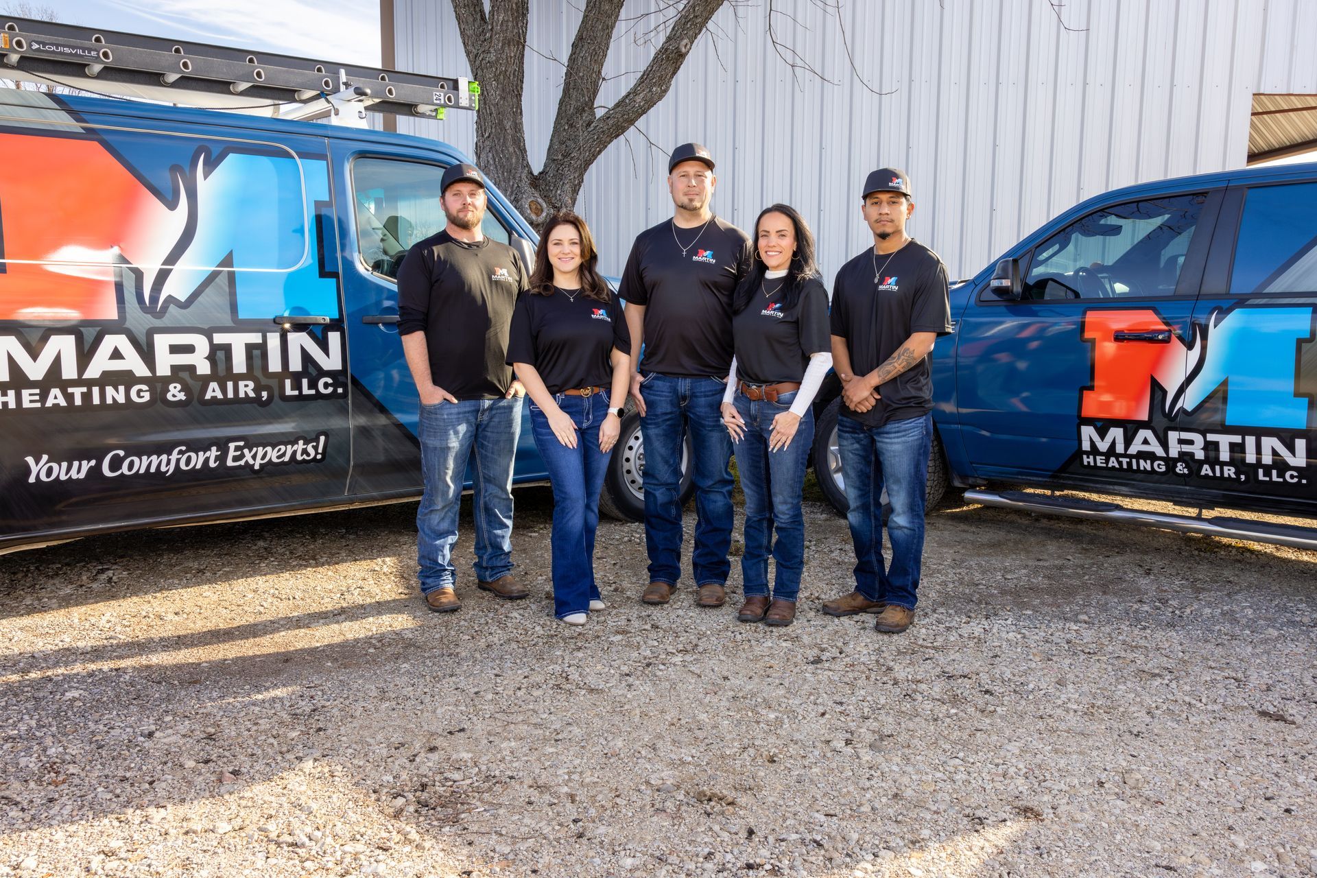 A man is sitting on the floor working on an air conditioner.