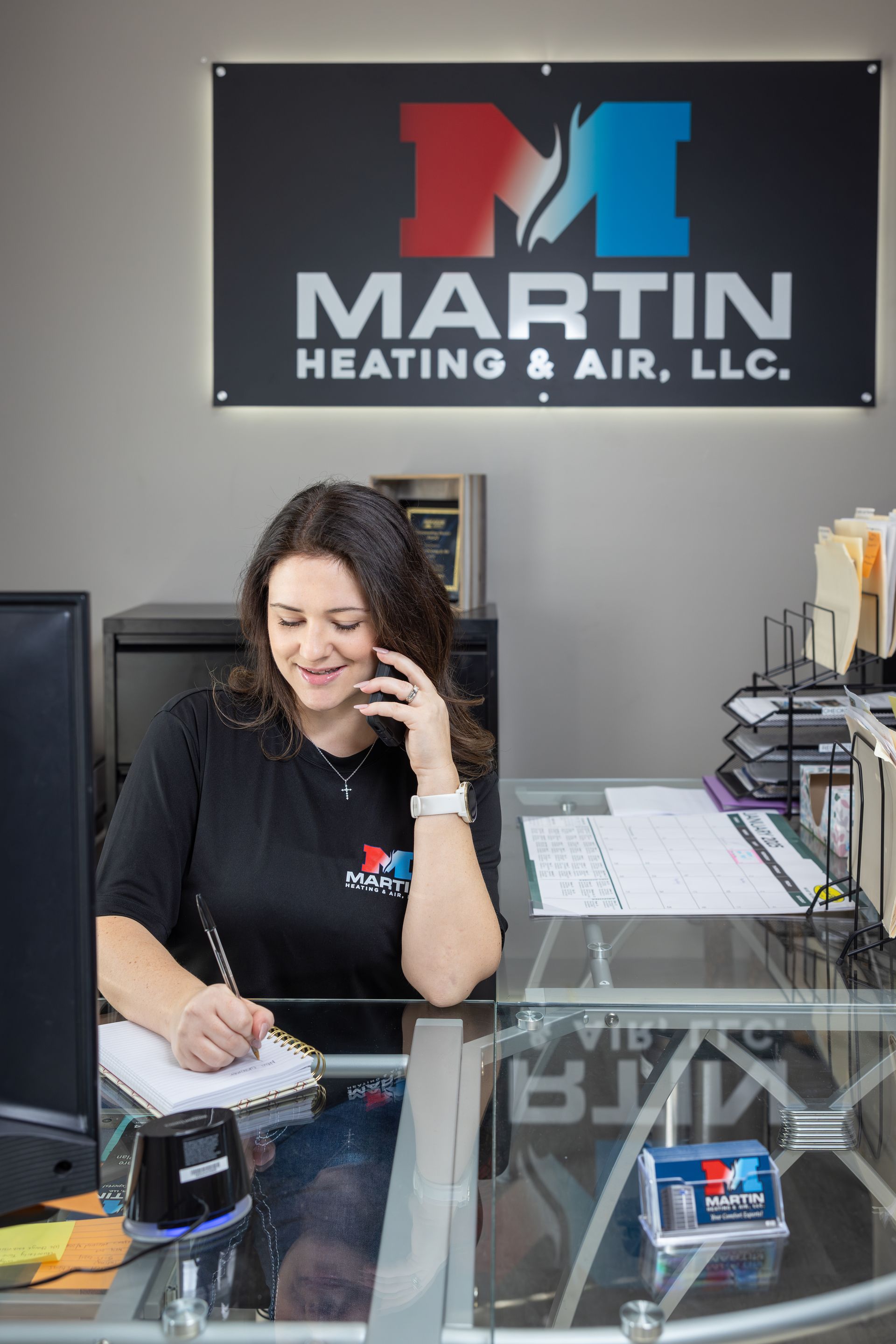 A man is standing on a ladder cleaning an air vent.