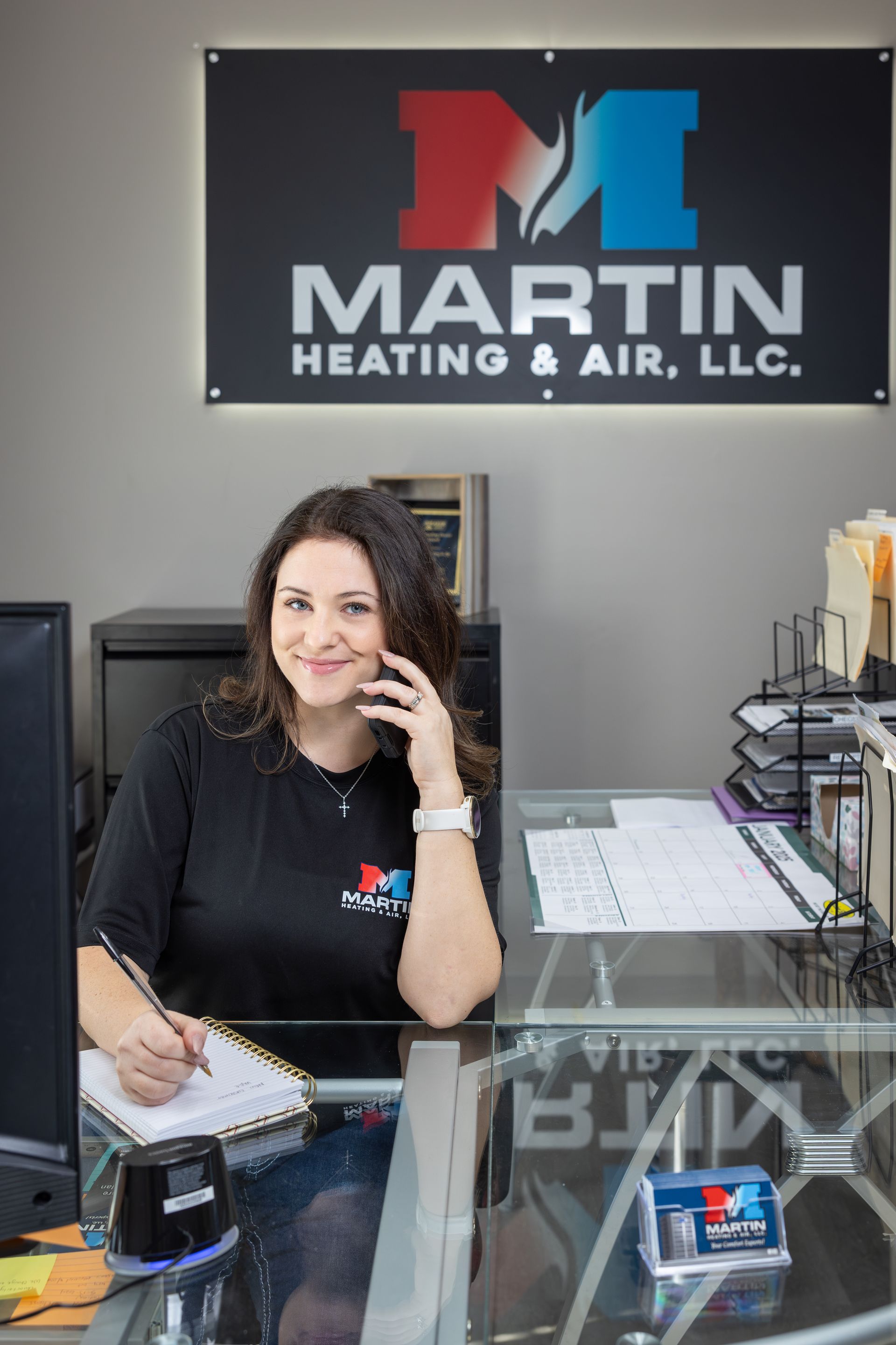 A man is standing next to an air conditioner holding a clipboard.