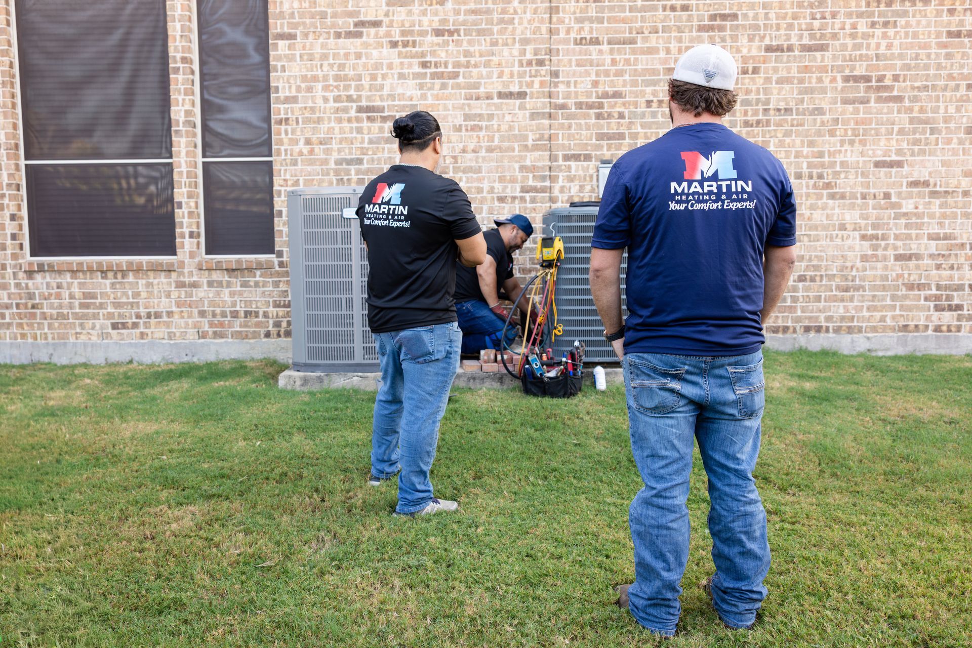 A woman is adjusting a thermostat with a smart phone.