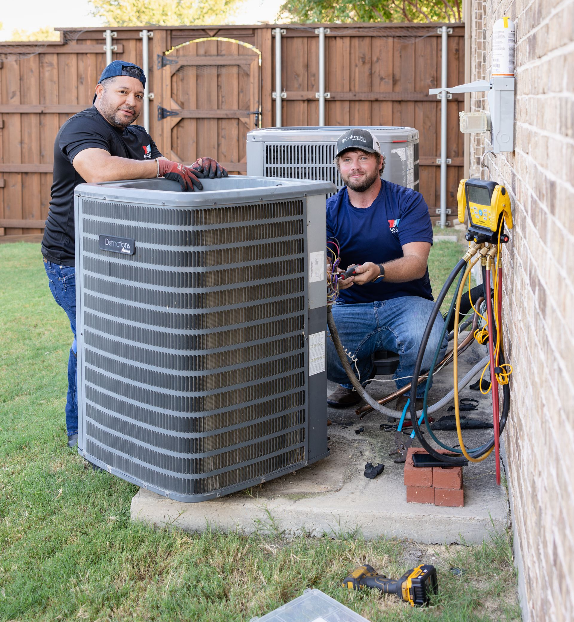 martin heating and air technicians are standing next to each other in front of a brick building.