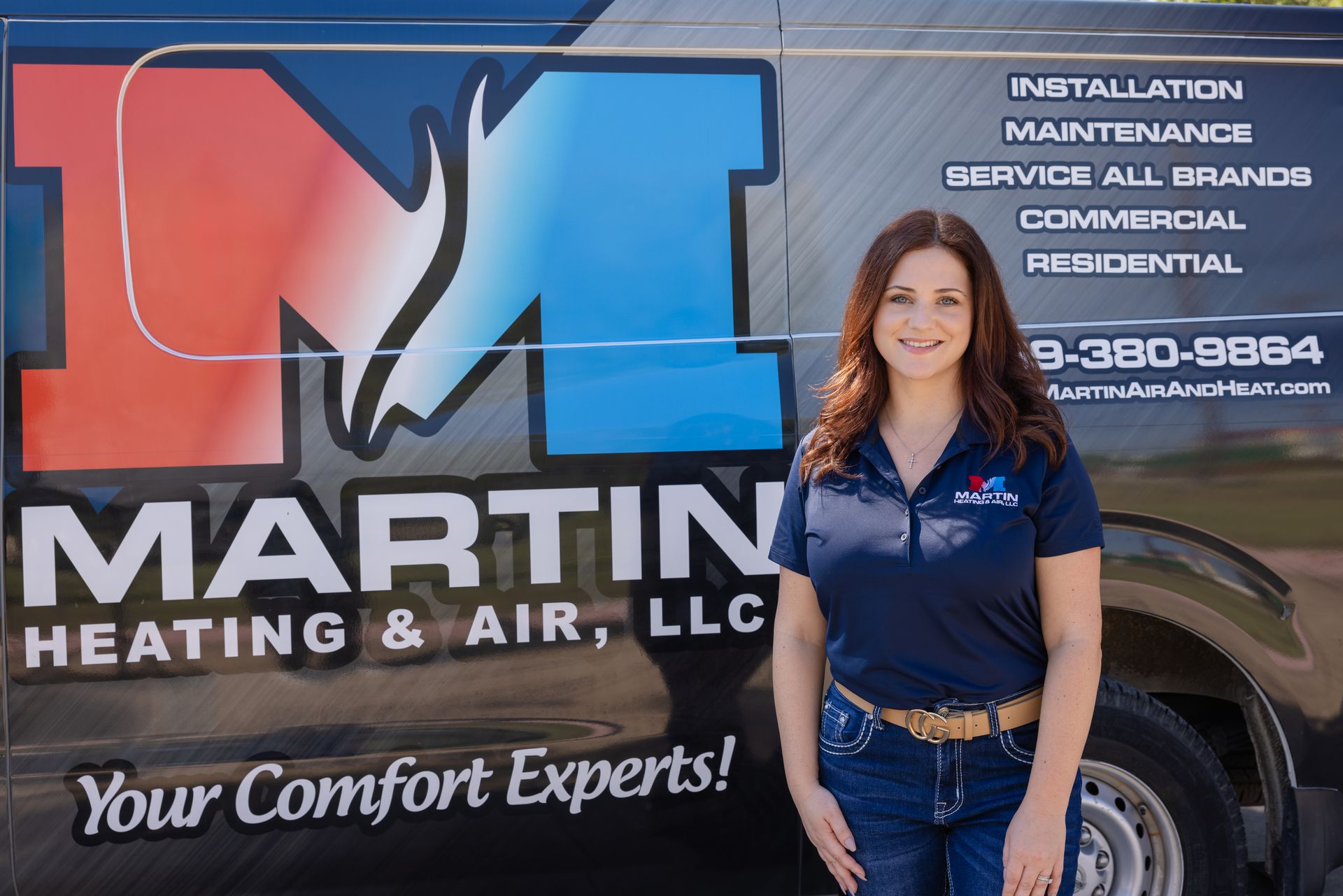 A woman is adjusting a thermostat with a smart phone.
