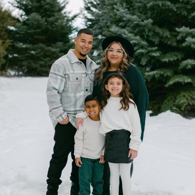 A family is posing for a picture in the snow.
