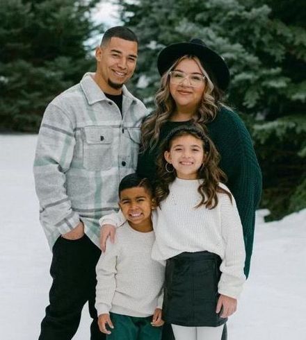 A family is posing for a picture in the snow.