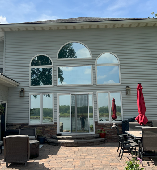 A large white house with a patio and a red umbrella